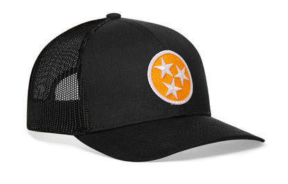 black trucker hat viewed from the right side, showcasing a bold orange and white embroidered flag patch prominently displayed on the front