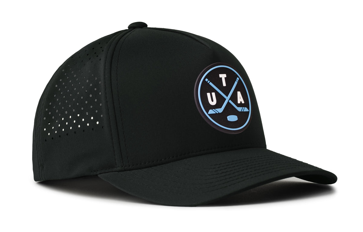 black performance 5-panel hat viewed from the right side, showcasing a bold navy and columbia blue pvc patch prominently displayed on the front
