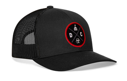 black trucker hat viewed from the right side, showcasing a bold black and red embroidered X patch prominently displayed on the front