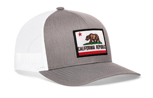 Gray-White trucker hat viewed from the right side, showcasing a California Flag Embroidered Rectangle Patch prominently displayed on the front