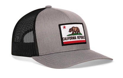 Gray-Black trucker hat viewed from the right side, showcasing a California Flag Embroidered Rectangle Patch prominently displayed on the front