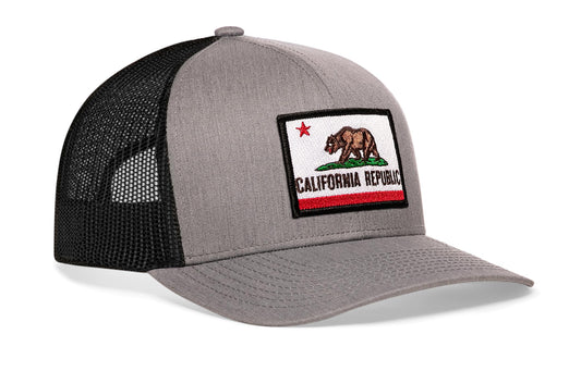 Gray-Black trucker hat viewed from the right side, showcasing a California Flag Embroidered Rectangle Patch prominently displayed on the front