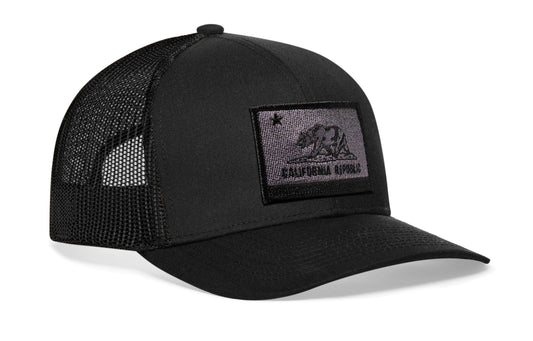 Black trucker hat viewed from the right side, showcasing a California Flag Embroidered Rectangle Tactical Patch prominently displayed on the front