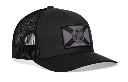 Black trucker hat viewed from the right side, showcasing a Florida Flag Woven Tactical Retangle Patch prominently displayed on the front