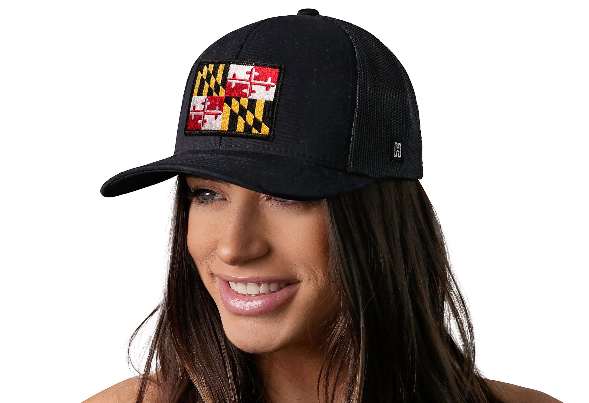 Black trucker hat worn by a female model viewed from the left side and features a Maryland Flag Embroidered Rectangle Patch displayed on the front panel. The hat has a classic mesh back design and a curved structured bill