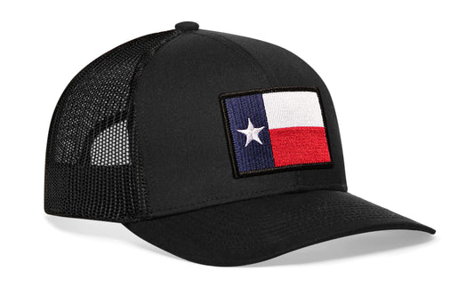 Black trucker hat viewed from the right side, showcasing a Texas TX Embroidered Flag Patch prominently displayed on the front