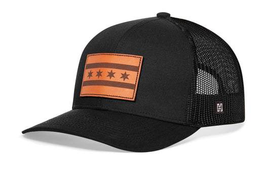 Chicago Trucker Hat, black snapback showing Haka brandmark on left side of cap.