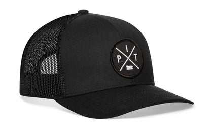 black trucker hat viewed from the right side, showcasing a bold black and white embroidered X patch prominently displayed on the front