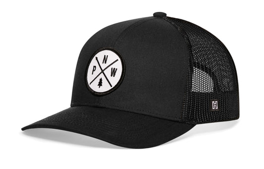Pacific Northwest Trucker Hat, black snapback showing Haka brandmark on left side of cap.