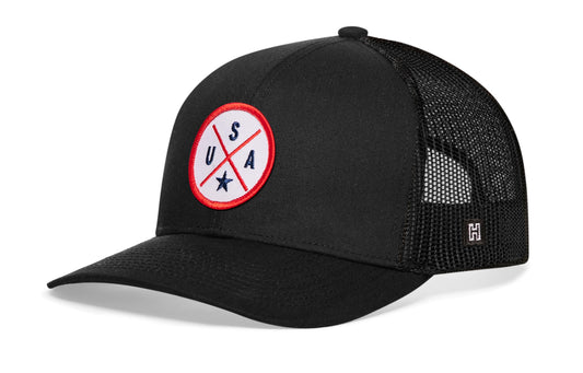 USA X Trucker Hat, black snapback showing Haka brandmark on left side of cap.